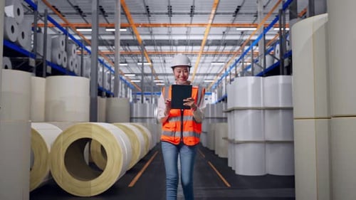 Front View of Asian Female Engineer Use Tablet While Walking at Polymer Plant