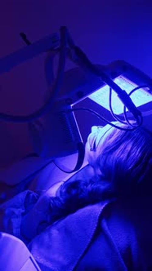 Woman Lying Underneath Medical Equipment in Blue Light