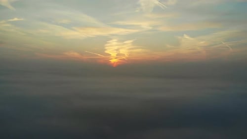 Scenic Aerial of Sun Rising Above Thick Clouds