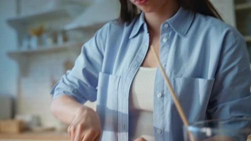 Woman Cutting Red Bell Pepper in Kitchen