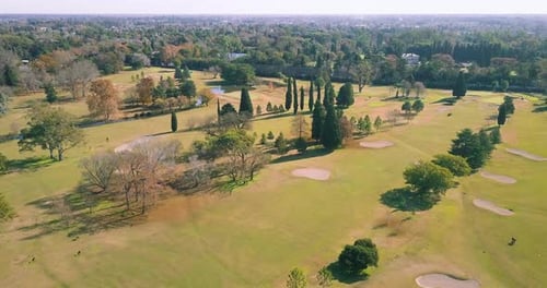 AERIAL - Sand traps and the green at a golf club, wide shot forward