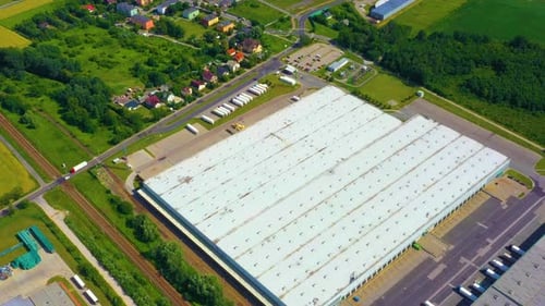 Aerial view of a semi trucks with cargo trailers standing on warehouses ramps for loading unloading