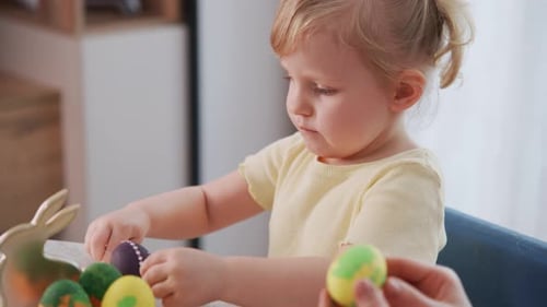 Child and Adult Collaborate on Painting Easter Eggs