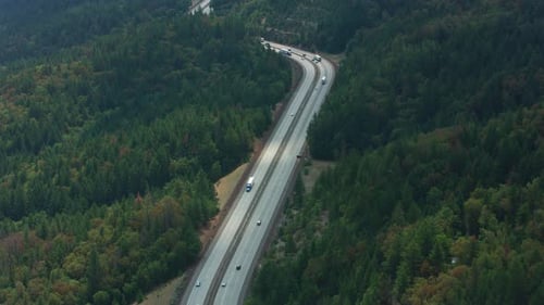Oregon i5 freeway winding through mountain pass at sunset aerial view