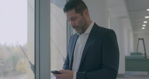 Corporate Businessman in Modern Office Using Smart phone