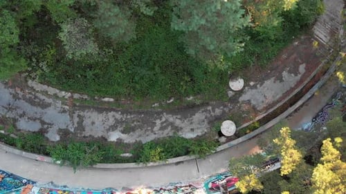 Vista aérea: pista olímpica de bobsleigh de Sarajevo en la montaña Trebević. Inyección cenital. Zumbido subiendo