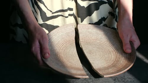 Woman's Hands Holding a Broken Ceramic Plate