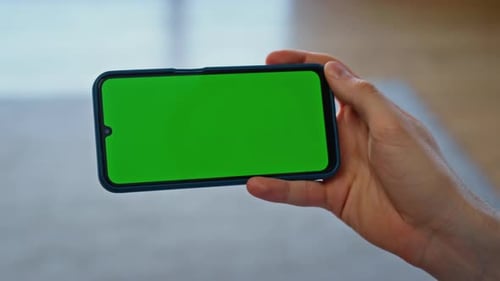 Smartphone in Nahaufnahme mit dem Finger auf der Vorlage, Nutzer hält Chroma-Key in der Hand