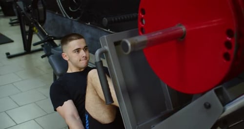 Young Adult Using Leg Press Machine at Gym