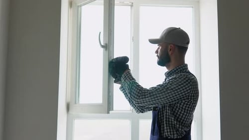 Master Installer in Overalls Installing or Adjusting Pvc Windows in Office or Apartment