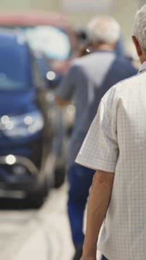 Elderly Man with Grey Hair Walking on Sunny Street