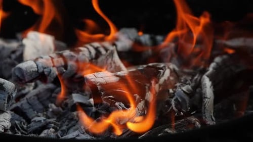 Burning Coals and Fiery Flames in Dark Background