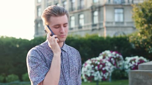 Young Man Talking on Smartphone in Urban Park