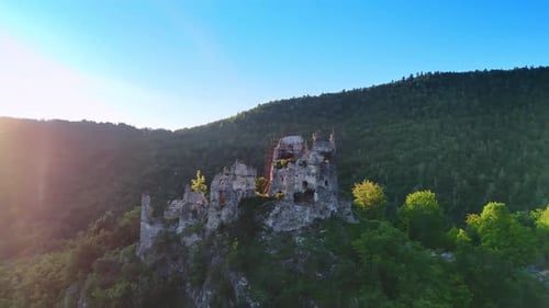 Flight around the castle ruins supported by the scaffolding on the rock.
