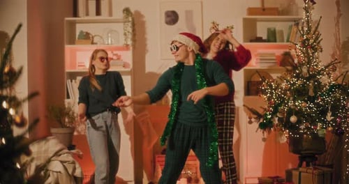 Friends Dancing near a Christmas Tree