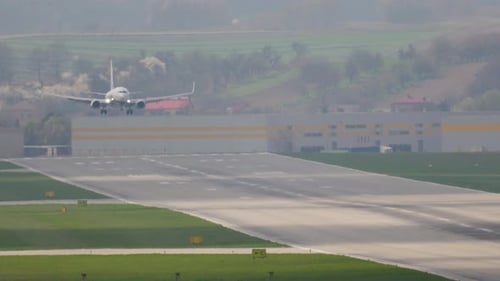 Graceful landing of a passenger aircraft at a bustling airport runway