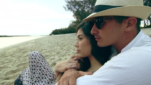 Stylish Young Couple, Cuddling on the Beach, Laying in the Sand, Looking