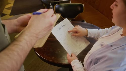 Unrecognizable Waiter Writing Down Order, Customer Pointing to Lunch Menu