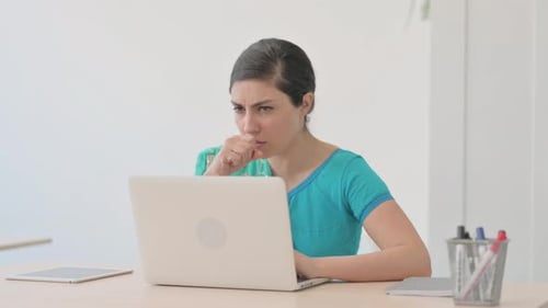 Hustende indische Frau in Sari arbeitet am Laptop