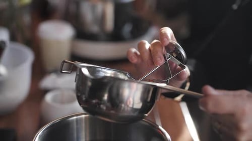 Girl Measures the Temperature of the Liquid with a Thermometer Side View