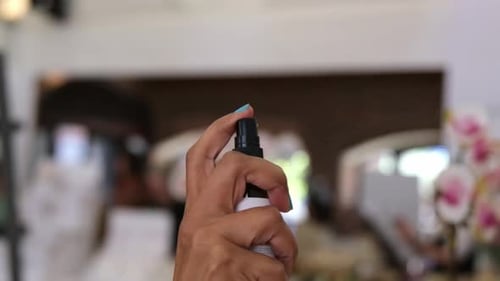 Hand spraying perfume in slow motion. Applies perfume. Spraying fragrance with scent.