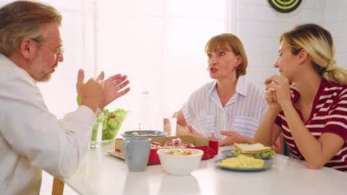 People Eating and Talking Together at Table