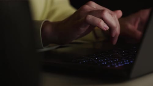 Anonyme Person, die nachts zu Hause Laptop benutzt