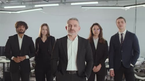The Director of a Consulting Firm Stands with His Employees People in Business Suits Pose Against
