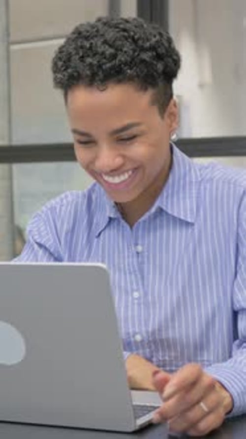 Smiling Woman Video Conferencing on Laptop in Office