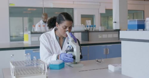 Woman Working with Microscope in Science Lab