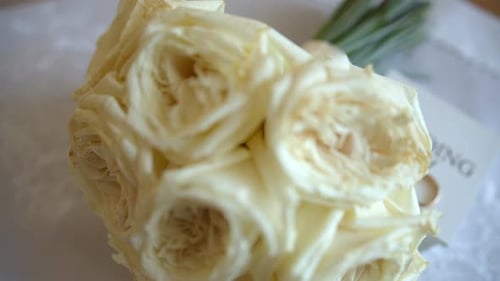 Close Up Shot of Engagement Wedding White Roses of Bridal Bouquet Lying on Bed