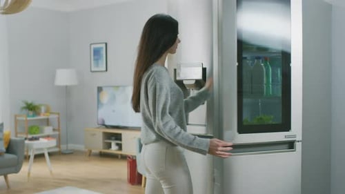 Woman Opens Modern Refrigerator in Stylish Apartment