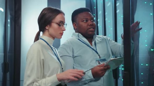 IT Professionals Engaged in Analyzing Complex Data Within a Server Room Environment