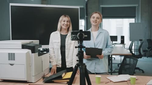 Business professionals engaged in a video meeting discussing project documents in a modern office