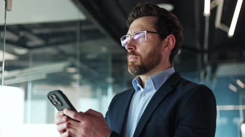 Earnest Office Manager Using Phone for Writing Message for Colleagues Indoors