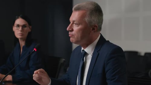 Speech Of Political Speaker At Meeting Room Of Business Center. Adult Man In Suit Explains Leader...