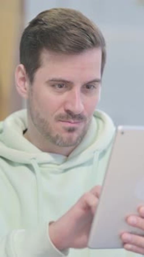 Man Using Tablet Device Rejoices at Good News