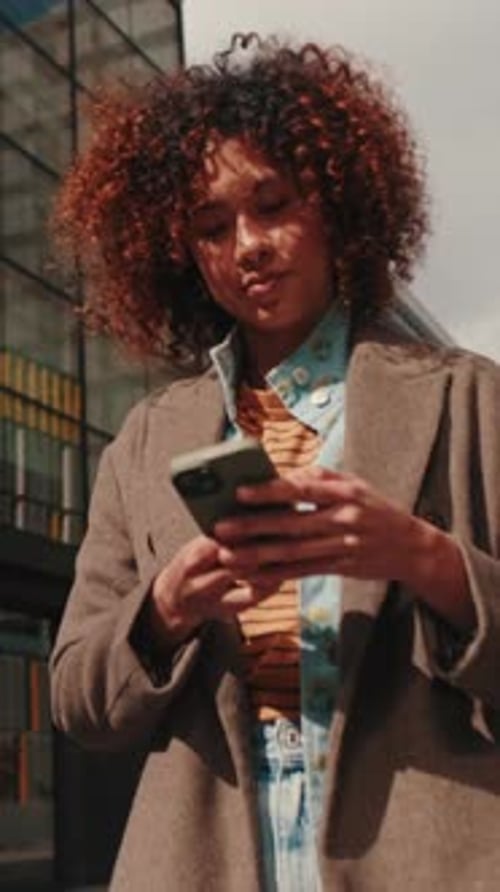 Vertical video, Happy Businesswoman Walks While Using Smartphone