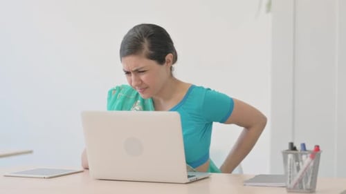 Woman with Back Pain at Computer in Office