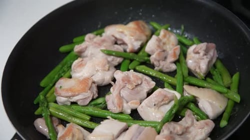 Preparing stir-fried chicken and asparagus