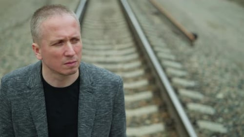 Contemplative Man on Railroad Tracks