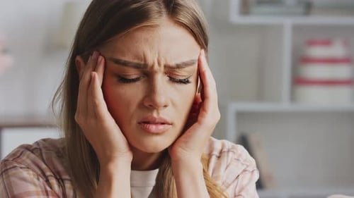 Woman Rubbing Temples Suffering from Headache