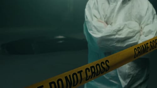 Investigator Standing Behind Crime Scene Tape at Night