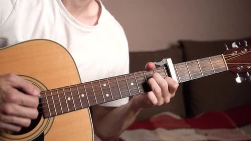 Person Playing Acoustic Guitar with a Guitar Pick