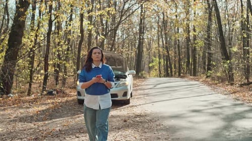 Woman with Car Trouble on Phone in Autumn Forest