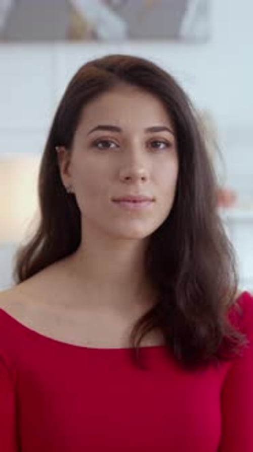 Une femme élégante vêtue d'une superbe robe rouge est magnifiquement capturée dans une lumière douce