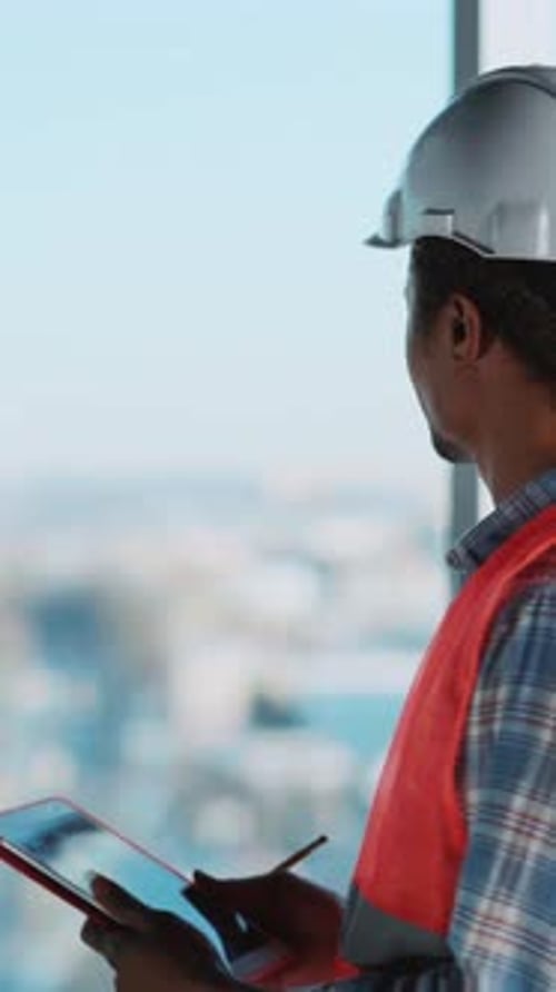 Afroamerican Civil Engineer Architect Standing Inside Glass Building Looking Outside Window Wearing