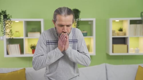 Hombre con problemas de salud que tose en casa y se siente mal.