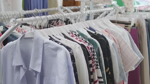 Various Clothing Items On Hangers On The Racks At The Boutique