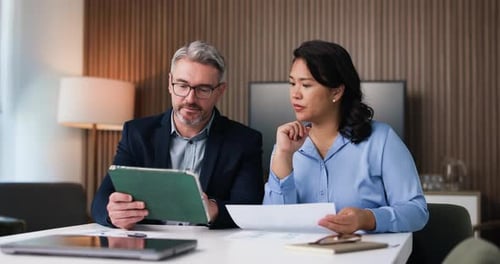 Colleagues Discussing Data on Tablet and Documents